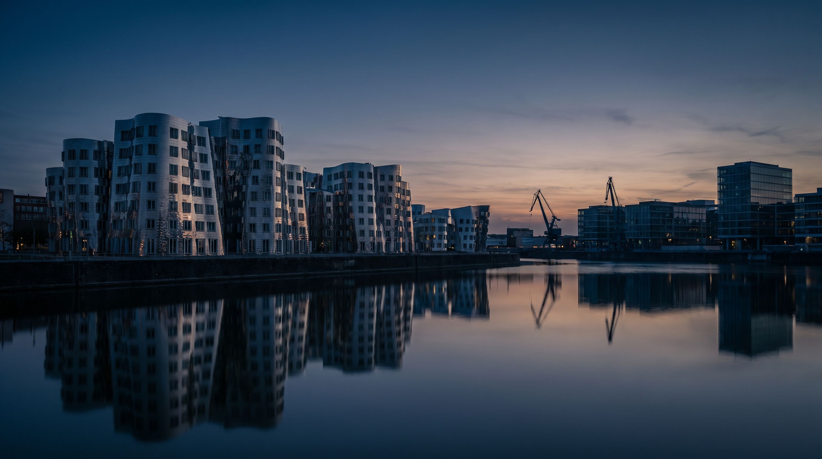 Düsseldorf Medienhafen — architektonische Silhouette der Quartierbauten zur blauen Stunde